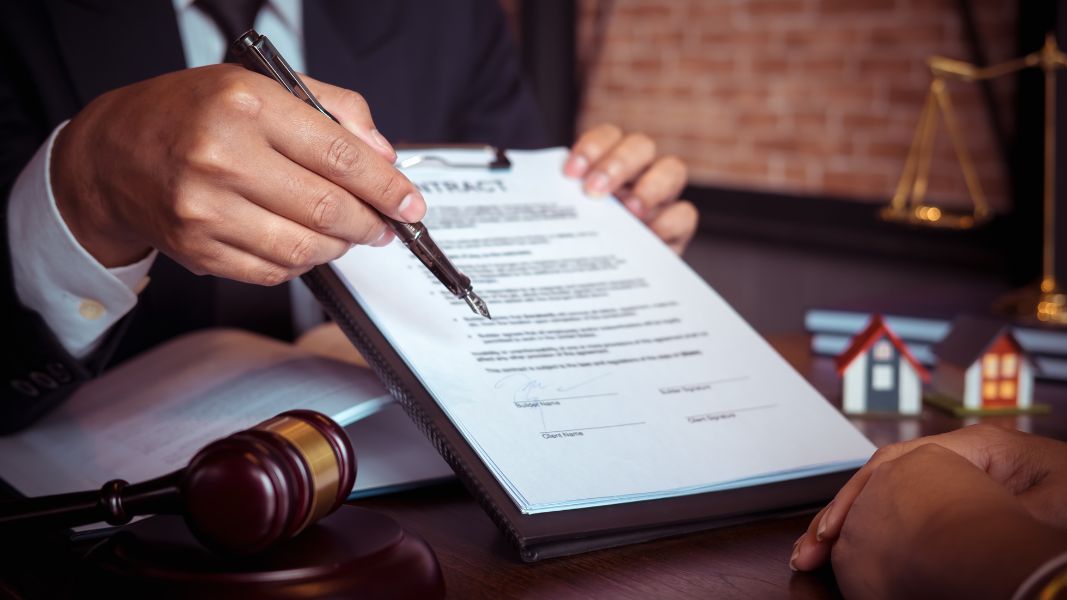 A photo of a lawyer holding a legal contract for a seller to sign